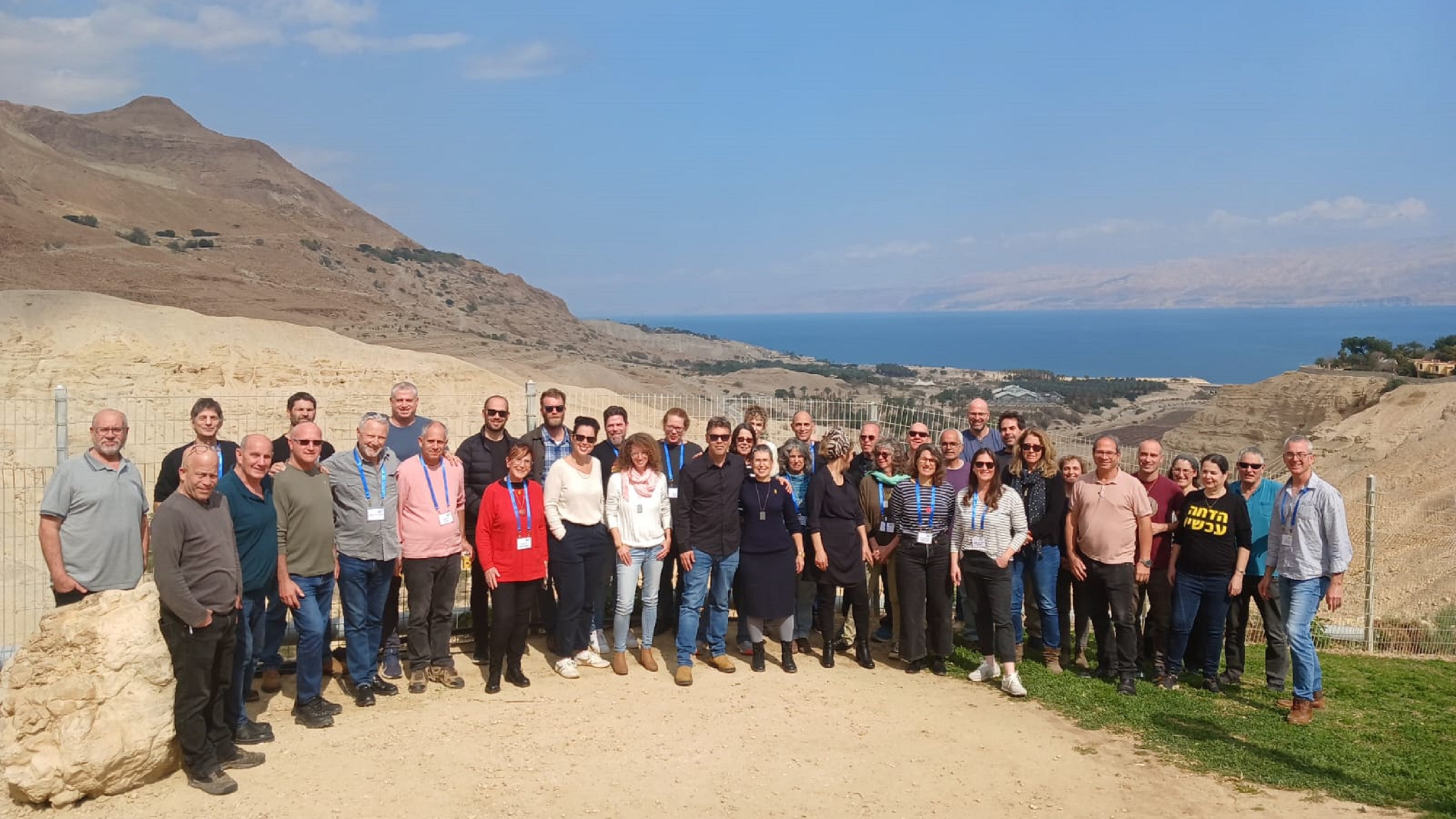 היי דרומה: נציגי הקיבוצים השיתופיים בתמונה קבוצתית על רקע הנוף היפה הנשקף מעין גדי